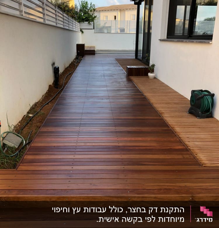 דק עץ חום עם צינור השקיה מגולגל